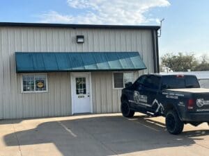 A business storefront with a truck parked in front.