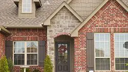 Brick house with brown door and shutters.