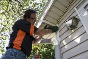 A man working on a house's exterior.