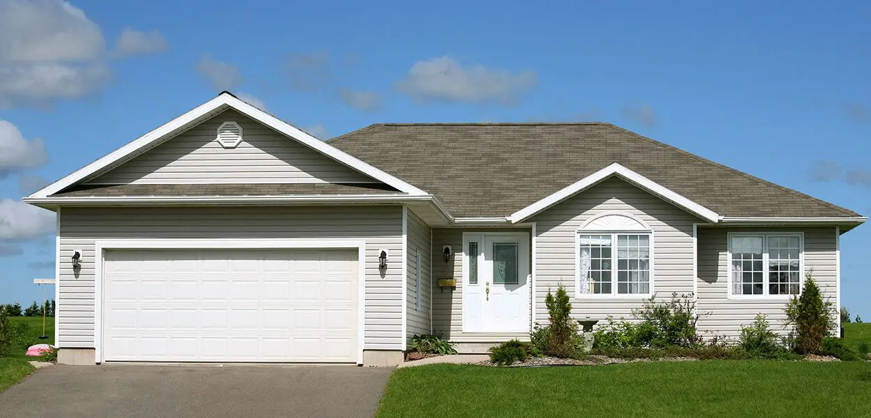 A beige house with a garage door.