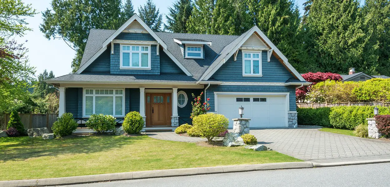 Blue house with a garage and lawn.